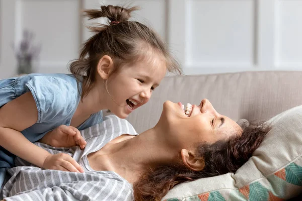 Yakın çekim kızı annesiyle kanepeye uzanmış birlikte vakit geçiriyor.