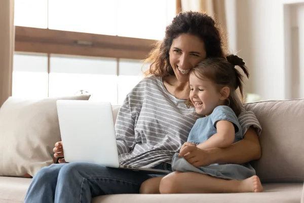 Mãe e pequena filha se divertindo assistindo desenhos animados no laptop — Fotografia de Stock