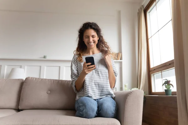Wanita memegang smartphone merasa bersemangat oleh berita yang diterima oleh sms — Stok Foto