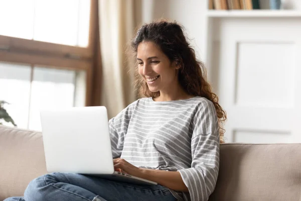 Žena úsměv sedět na gauči dát PC na klíně číst příjemné zprávy — Stock fotografie
