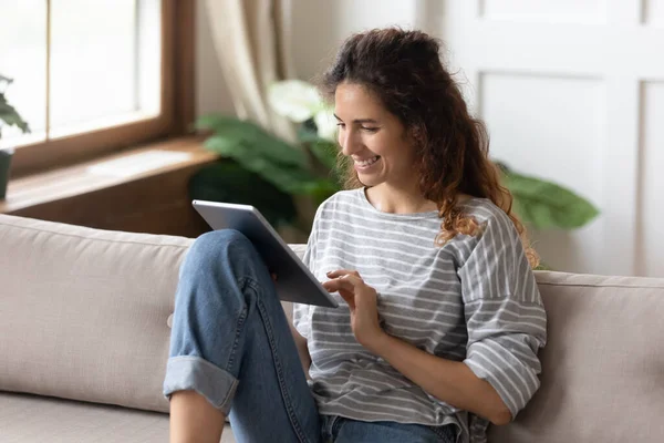 Žena sedí na pohovce pomocí tabletu zařízení nákup na internetu — Stock fotografie