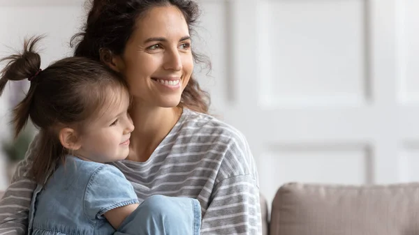 Mutter und kleine Tochter sitzen auf Sofa und lächeln weg — Stockfoto