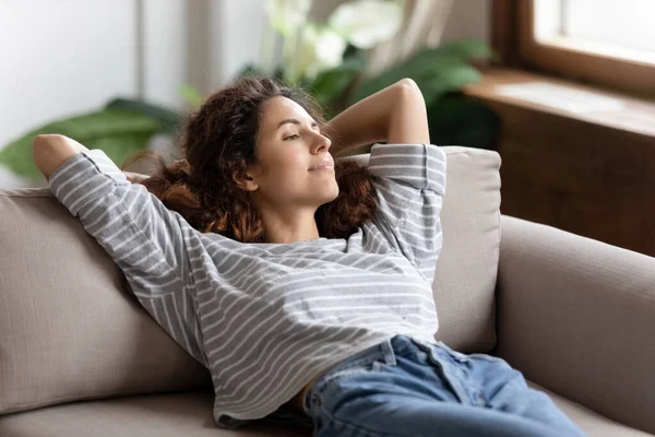 Klidná žena odpočívající na pohovce trávit líný čas doma — Stock fotografie
