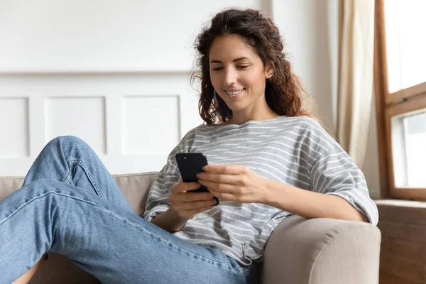 Vrouw ontspannen thuis met smartphone tijd doorbrengen op internet — Stockfoto