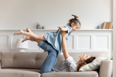 Annesi kanepede uzanmış, kendini uçak sanan kızı.