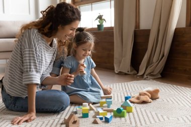 Anne ve kız renkli tahta tuğla oyuncaklarla oynuyorlar.