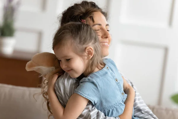 Cariñosa mamá abrazo pequeña hija da su ternura y amor — Foto de Stock