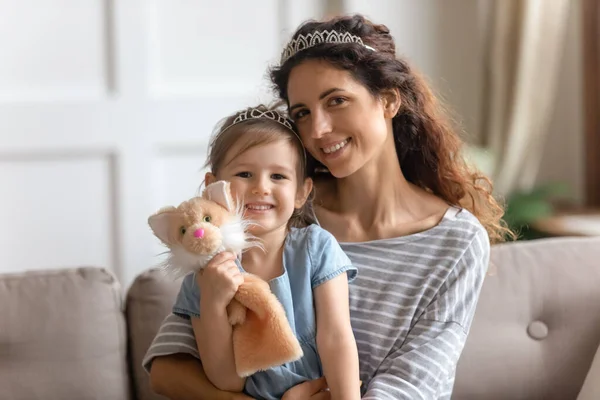 Fille tenant marionnette jouet posant pour la photo avec la mère — Photo