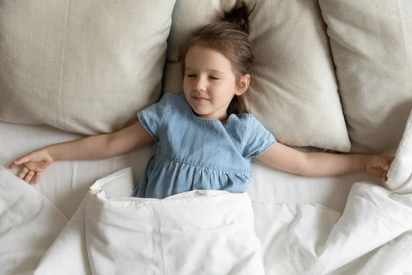 Top melihat gadis kecil menikmati tidur siang yang sehat berbaring di tempat tidur — Stok Foto