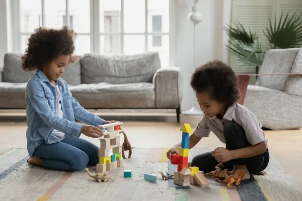 Smiling adorable mixed race small children siblings playing toys.