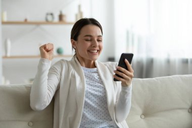 Neşeli, gülümseyen genç bir kadın iyi haber almamızı kutluyor..