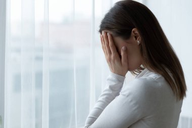Çaresiz stresli kadın, ellerinde yüzünü gizliyor, depresyondan acı çekiyor..