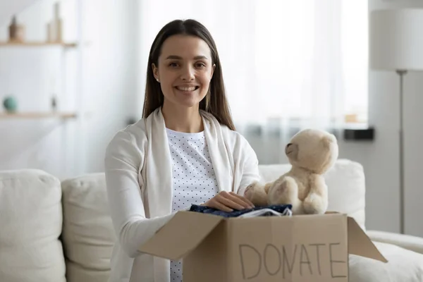 Gelukkig jong vrouw holding karton donatie doos op ronden. — Stockfoto