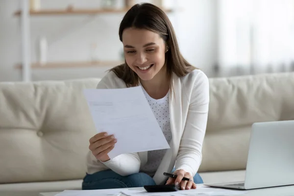 Sorrindo jovem bela mulher lendo notificação papel bancário. — Fotografia de Stock