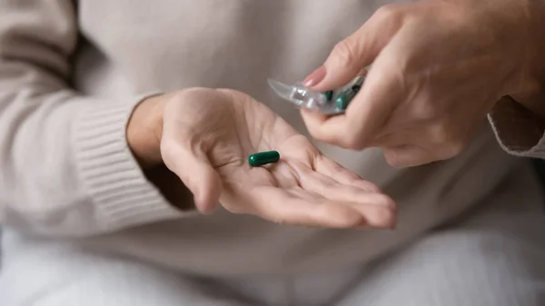 Reife Frau nimmt Pille aus Verpackung — Stockfoto