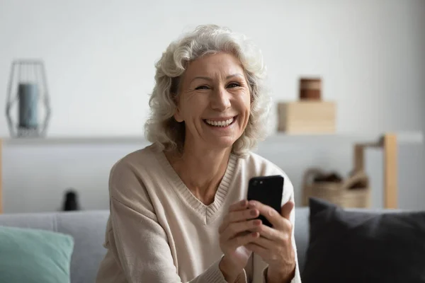 Голова портрет улыбается красивая зрелая женщина держит смартфон — стоковое фото