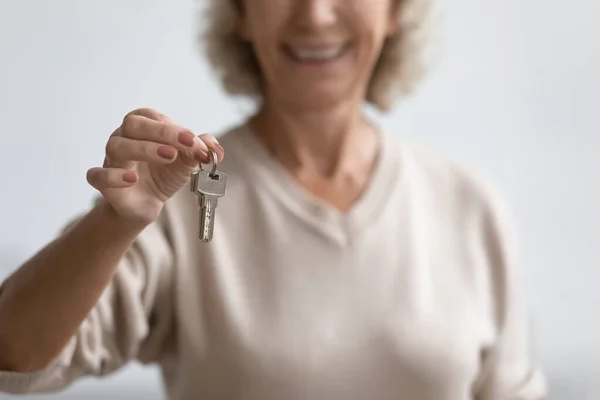 De cerca sonriente mujer madura sosteniendo nuevas llaves de la casa — Foto de Stock