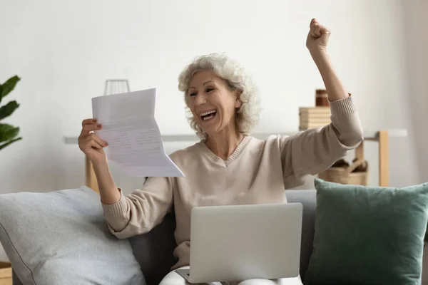 Überglückliche reife Frau liest gute Nachrichten in Briefen und hält Papiere in der Hand — Stockfoto