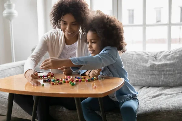 Mujer afroamericana enseñando a su hija a crear accesorios hechos a mano. — Foto de Stock