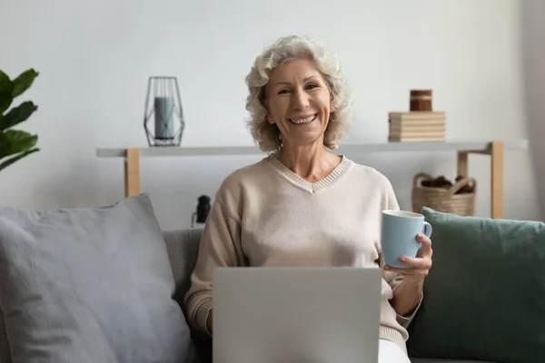 Porträt lächelnde reife Frau genießt Freizeit mit Laptop — Stockfoto