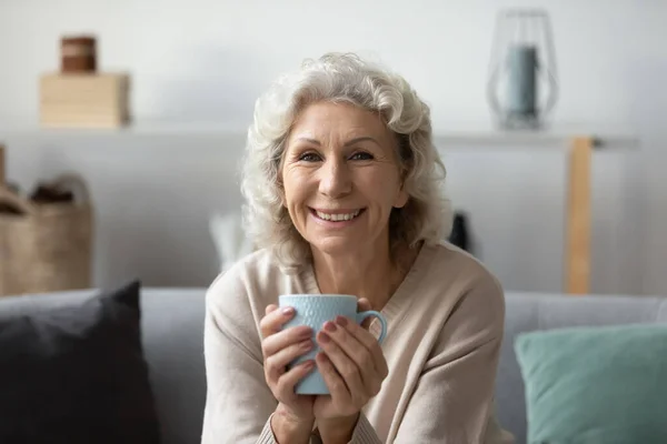 Kopfschuss Porträt lächelnde reife Frau trinkt Tee — Stockfoto