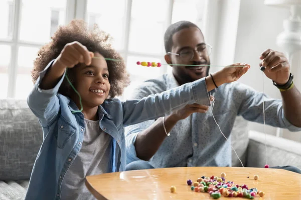 Feliz niña birracial involucrado en la actividad hecha a mano con el padre. — Foto de Stock