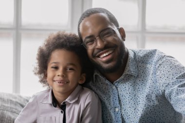 Sevecen, mutlu, melez babanın sevimli oğluna sarılışının portresi..