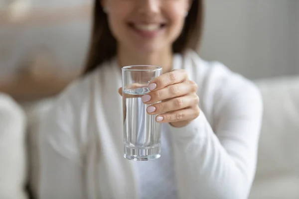 De cerca sonriente joven sana sosteniendo vaso de agua pura. — Foto de Stock