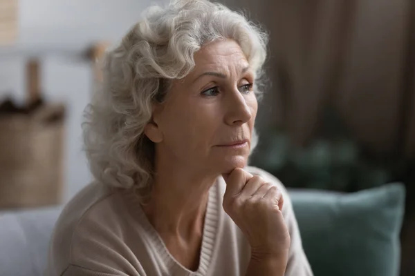 Close up thoughtful middle aged woman looking to aside — Stock Photo, Image