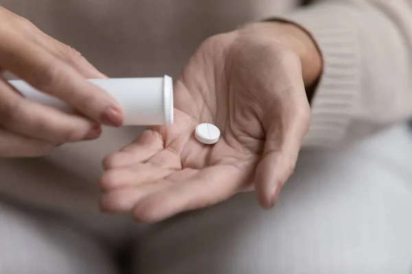 Närbild mogen kvinna tar ut piller från plastflaska — Stockfoto