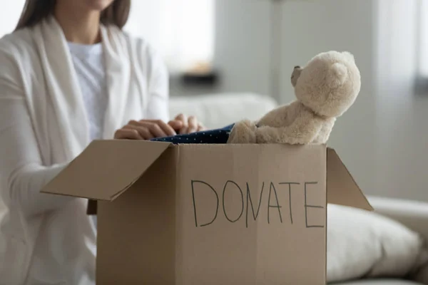 Vriendelijke vrijwilliger zet dingen voor arme gezinnen in liefdadigheidspakket. — Stockfoto