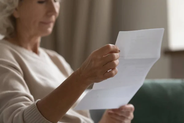 Nahaufnahme ernste reife Frau beim Lesen von Briefen, sitzend auf der Couch — Stockfoto