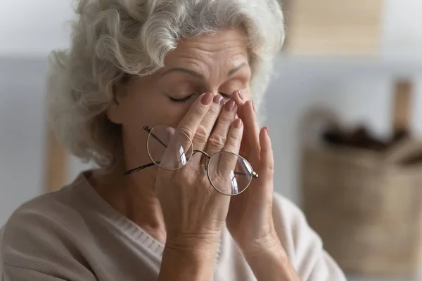 Fechar esgotado mulher madura sofrendo de tensão ocular — Fotografia de Stock