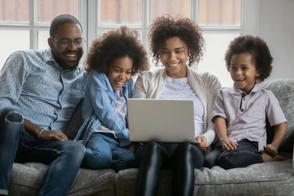 Familia afroamericana feliz viendo película en la computadora. — Foto de Stock