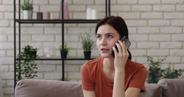 Kobieta umawia się telefonicznie siedzieć na kanapie w domu — Wideo stockowe