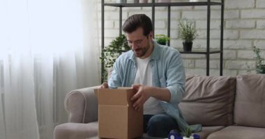 Millennial Man paket kutusunu açıyor ve teslim edilen mallardan memnun.