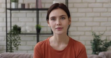 Kanepede oturmuş kameraya gülümseyen portre kadın.