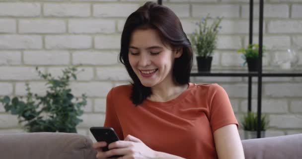 Молодая женщина весело провести время с помощью мобильного телефона смеется над смешным видео — стоковое видео