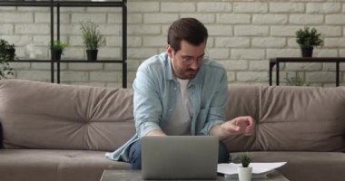 Ev faturalarını kontrol eden adam online ödemeleri yapan bilgisayarı kullanır