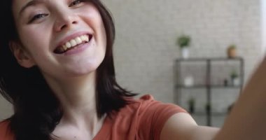 Coquette kadınının elinde akıllı telefon kayıtları var. Kamera için video dansı hareketleri.