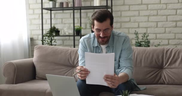 Millennial man läsa papper brev känns upphetsad av goda nyheter — Stockvideo