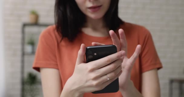 スマートフォンを使っている女性が受信したメッセージのクローズアップビューで笑う — ストック動画