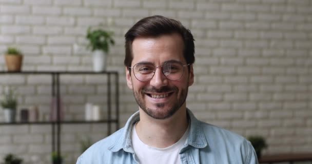 Cabeza retrato millennial hombre en gafas sonrisa mira a la cámara — Vídeos de Stock