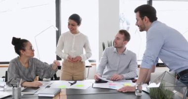 Mutlu iş adamları ekibi iş yerinde beşlik çakıyor.