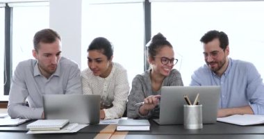 Profesyonel çok kültürlü iş arkadaşları çevrimiçi proje kullanımı laptoplarını tartıştılar