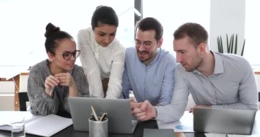 Ofiste çalışan çok ırklı iş adamları ortak projeyi bilgisayarda tartışıyor