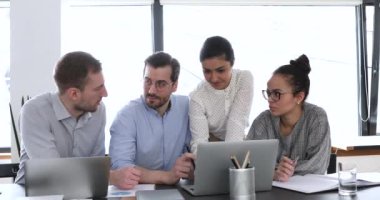 İş adamları ofiste toplandı. Laptop kullanarak ortak projeyi tartıştılar.