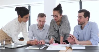 Ofis masasında çok ırklı işçiler grubu beyin fırtınası