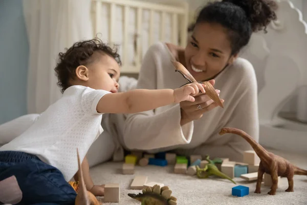 Adorable curious little mixed race baby playing toys with nanny. — Stock Photo, Image