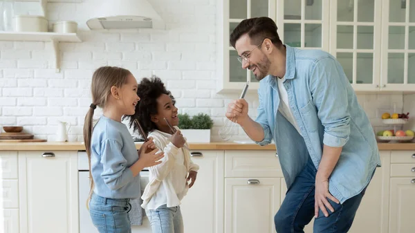 Überglückliche interrassische Familie, die an lustigen häuslichen kreativen Aktivitäten beteiligt ist. — Stockfoto